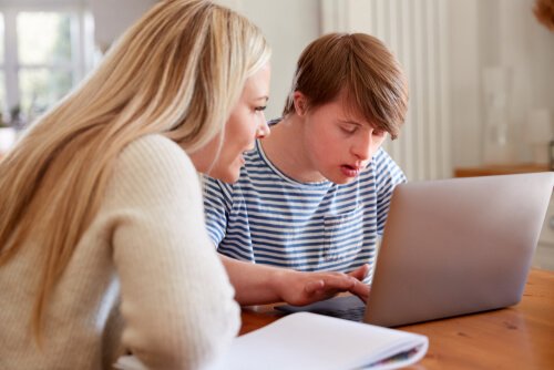 A man with autism using the web with the help of a woman