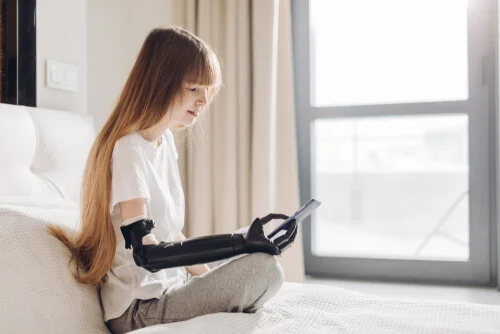 women with robotic hand holding phone