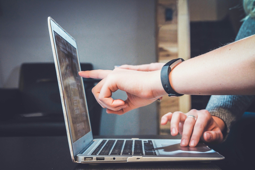 user pointing at a laptop screen