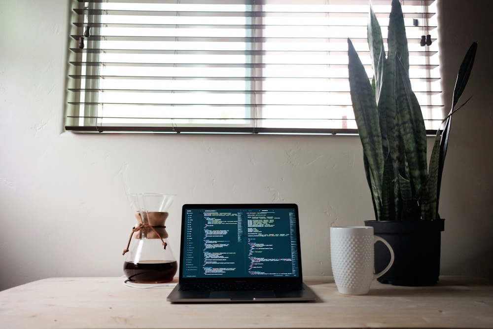a laptop on a desk with code on the screen