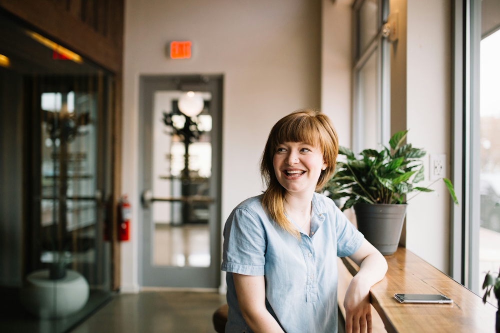 a smiling female employee sitting at a desk