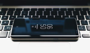 a mobile phone laying on a laptop keyboard