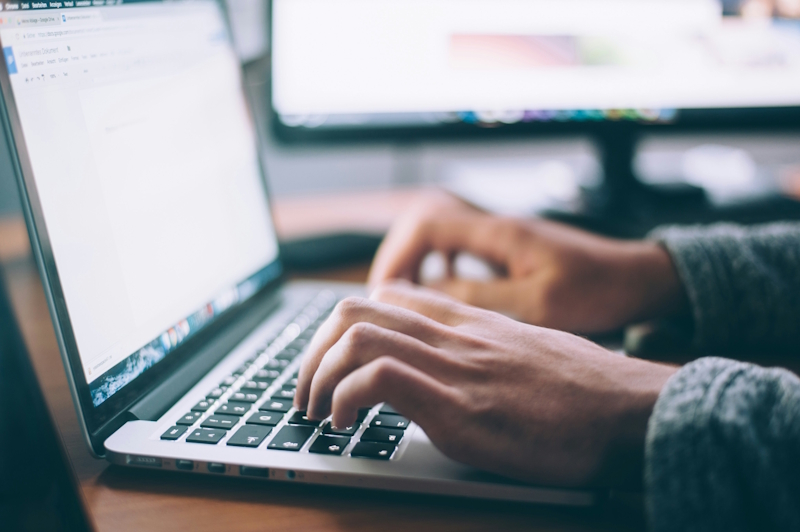close up of a person typing on a laptop