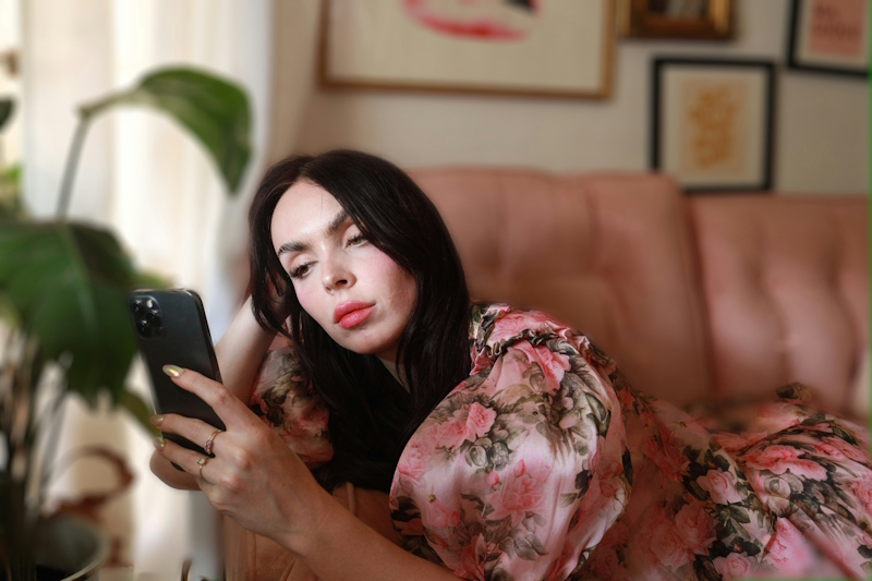 a woman laying on a couch looking at her phone