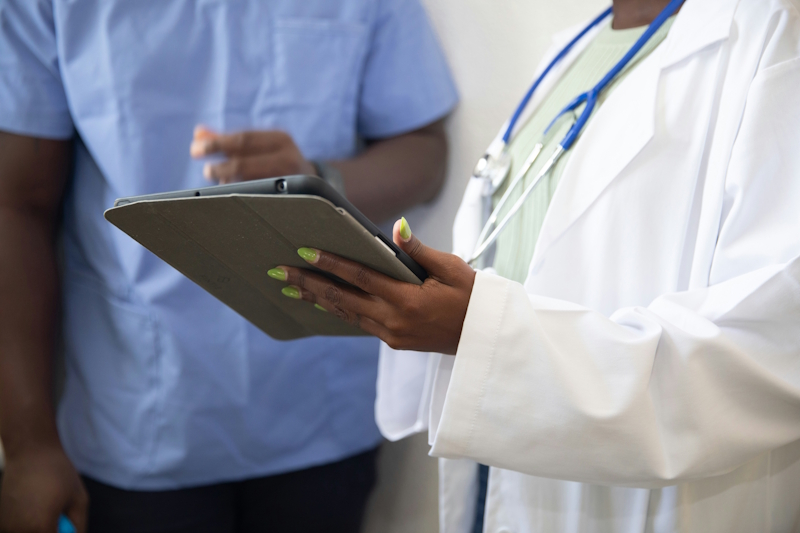 a doctor holding a tablet talking to a patient